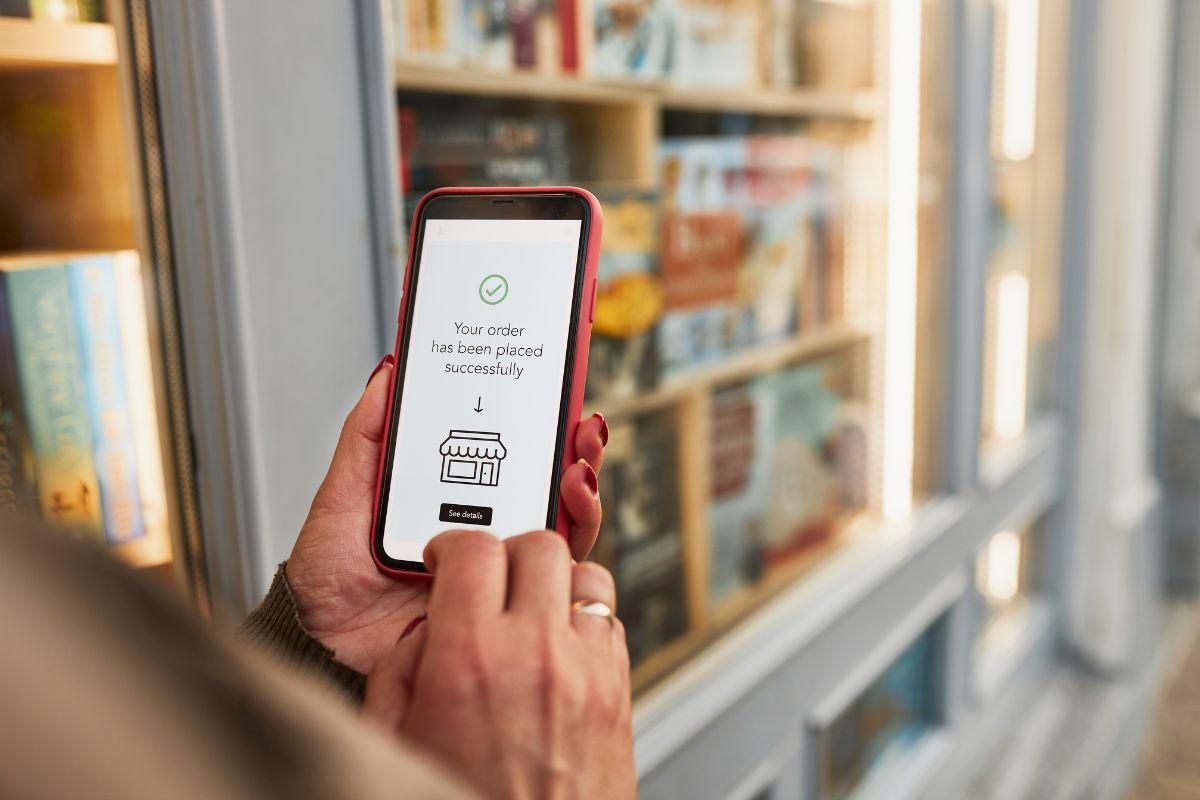 Person holding a smartphone displaying a confirmation message that an order has been placed successfully.