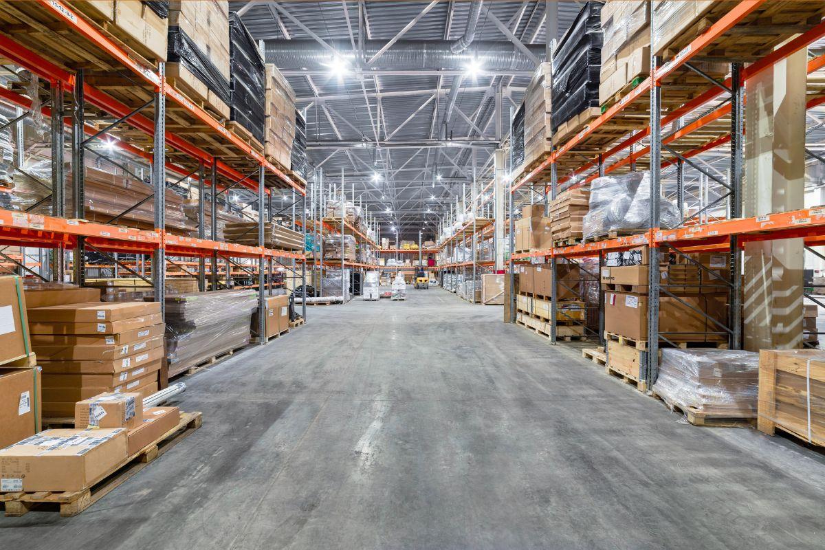Large warehouse with high shelves filled with various pallets and boxes.