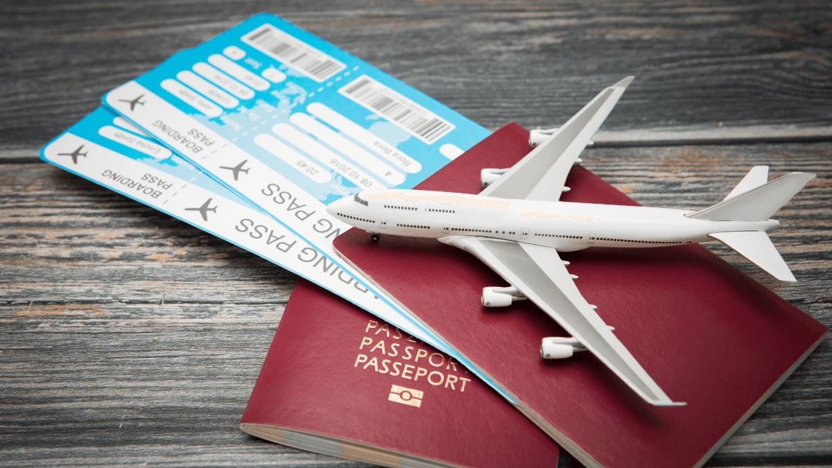Travel essentials with two passports, boarding passes, and a model airplane on a rustic wooden surface, symbolizing the excitement of an upcoming journey.