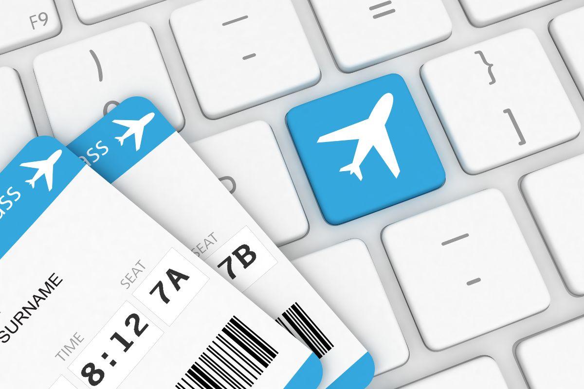 Two airline boarding passes placed on a keyboard with a blue key featuring a white airplane icon, symbolizing online booking.