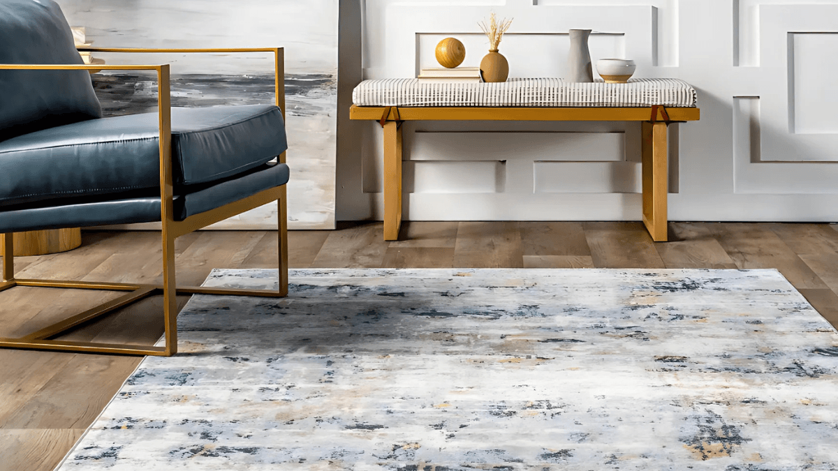 A modern living space featuring a stylish armchair with golden accents, a textured area rug with abstract patterns, and a wooden bench adorned with minimalist decor, creating a cozy yet elegant ambiance.