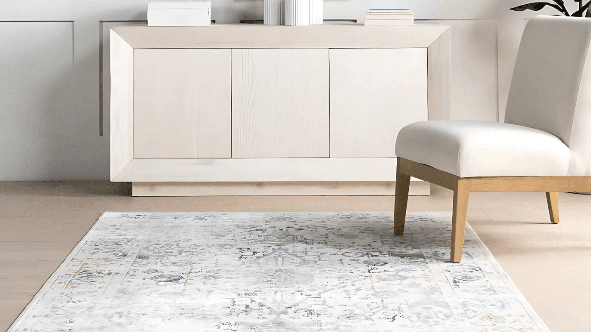 Elegant room showcasing a light, abstract-patterned area rug paired with a minimalist wooden chair and modern sideboard, creating a serene and sophisticated interior.