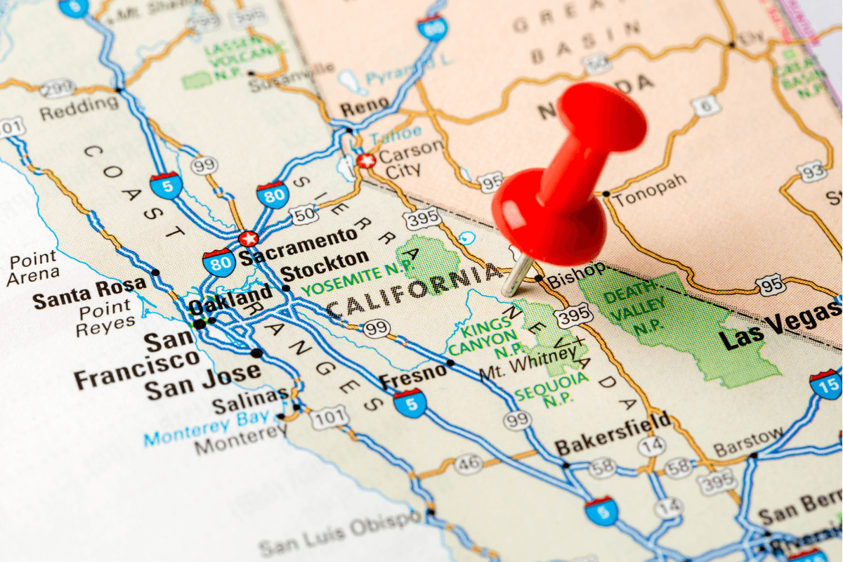 A close-up of a map showing the state of California with a red pushpin marking a location.