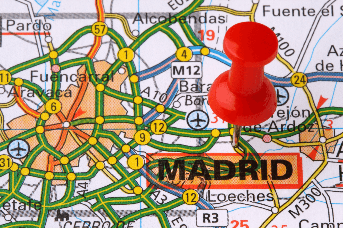 Close-up of a map with a red pushpin marking the location of Madrid, Spain.