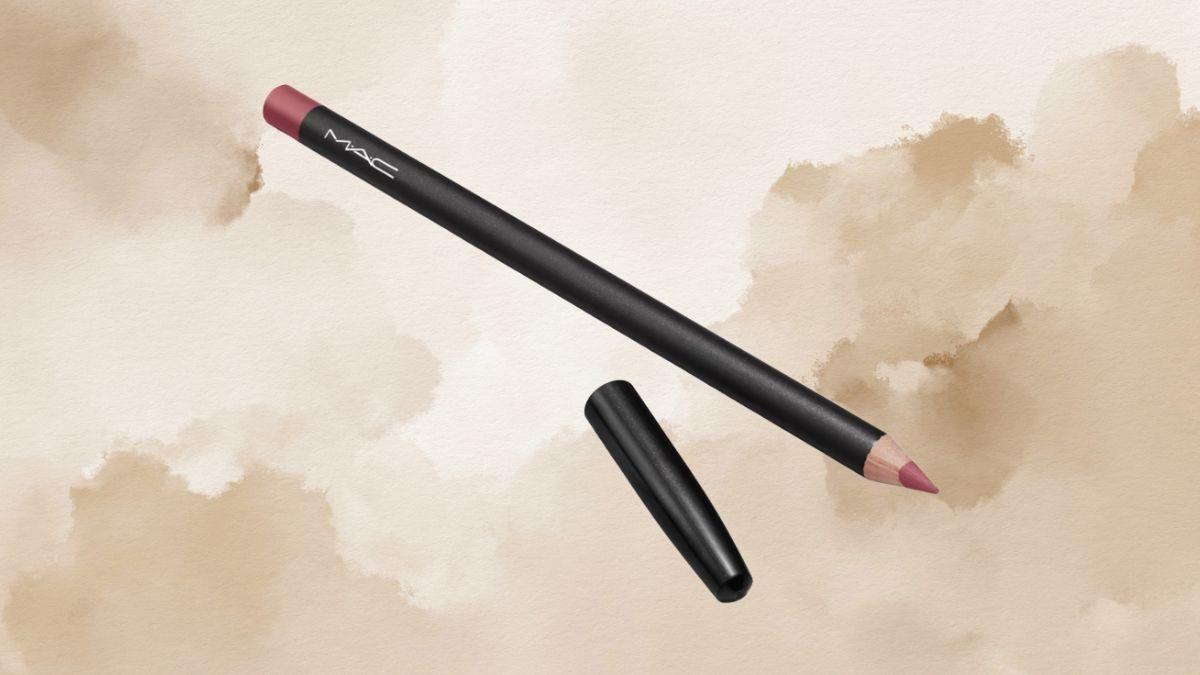 A MAC lip liner pencil with a pinkish tip and black casing is displayed on a beige watercolor background with its cap removed.