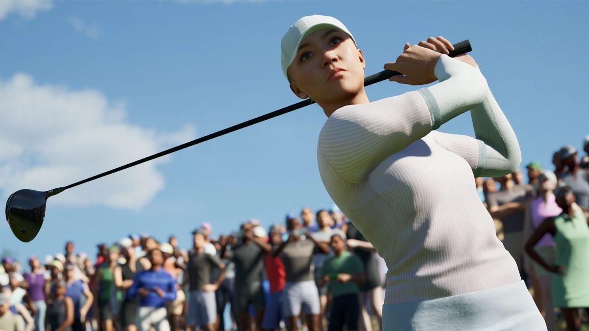 A female golfer swings her club on a bright day, with a crowd watching in the background.