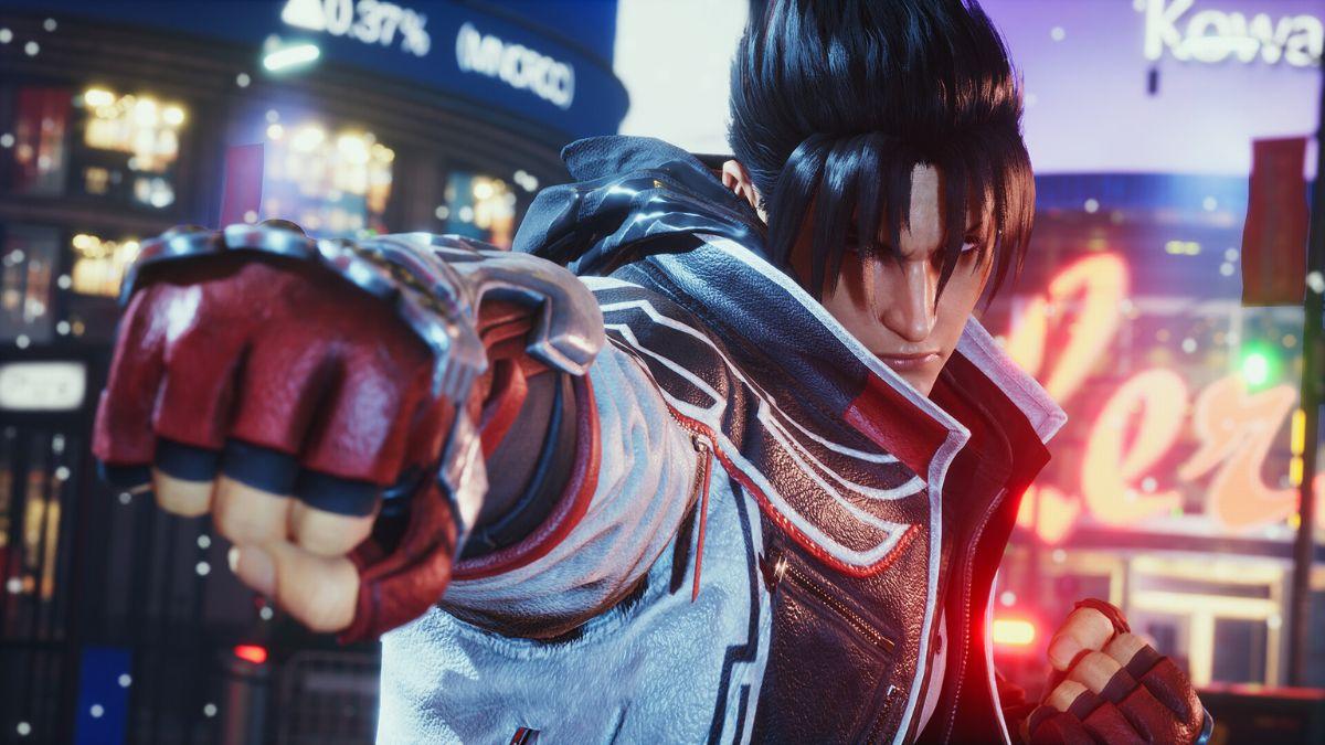 A close-up of a Tekken 8 character with a clenched fist, wearing a red and white jacket, standing in a neon-lit city.