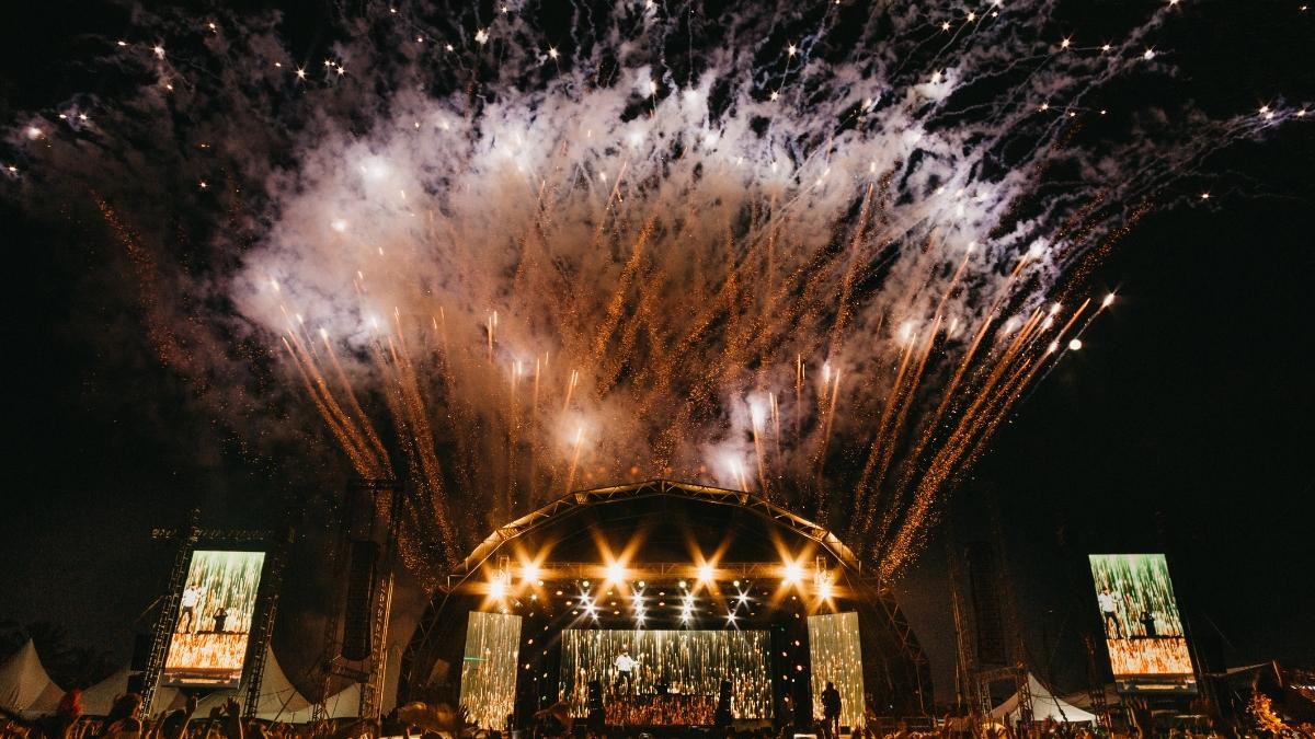 Fireworks bursting above a live concert stage at night with bright lights and a cheering crowd — perfect visual for the Complete Guide to StubHub Tickets and live event experiences.