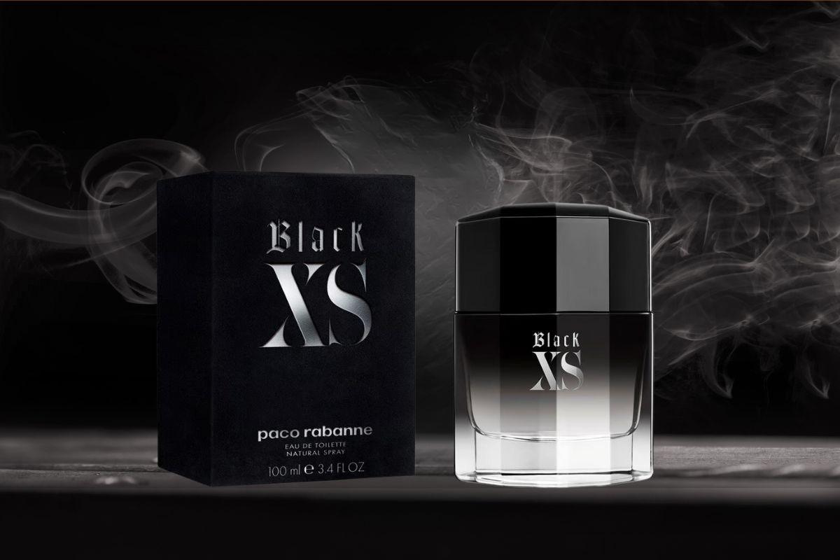 Paco Rabanne Black XS perfume bottle and box displayed with smoky accents on a dark background.