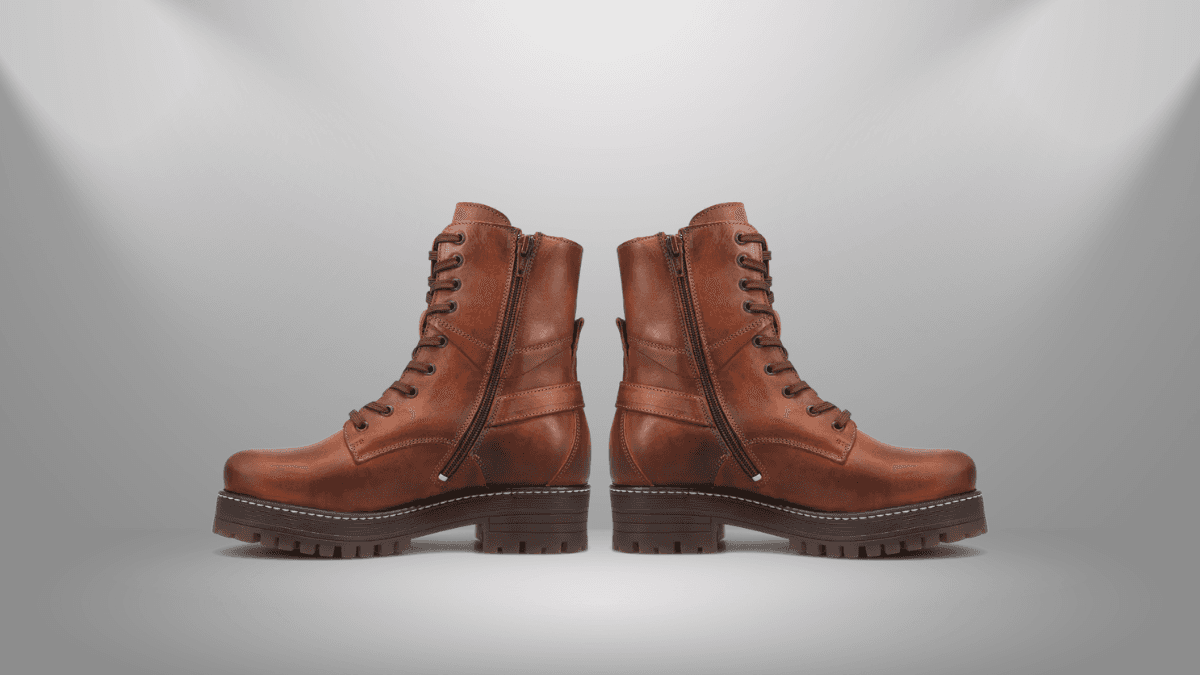 Brown leather boots with rugged soles, lace-up fronts, and side zippers, set against a minimalist background.