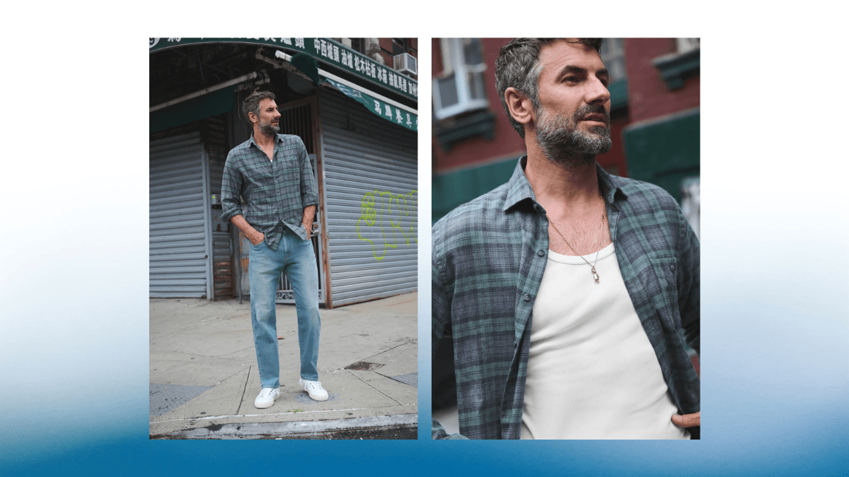 A relaxed plaid shirt styled effortlessly over a white tank top and paired with casual blue jeans and sneakers. The urban backdrop adds a modern edge to this laid-back look.