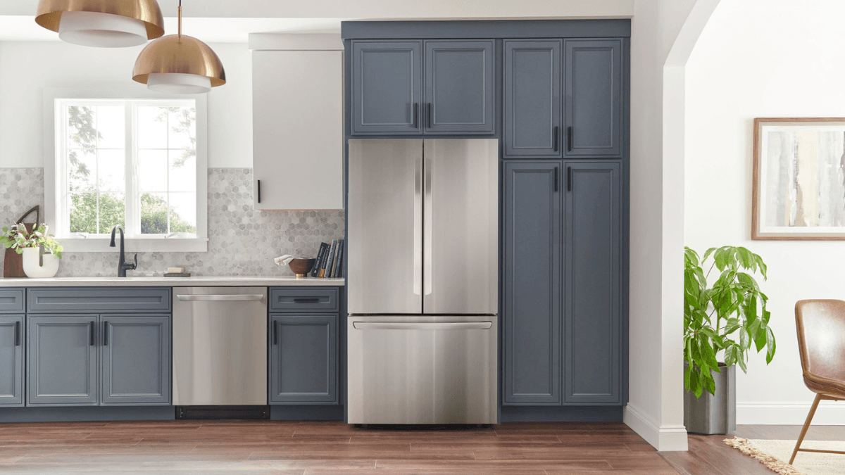 Modern kitchen design featuring navy blue cabinets, stainless steel French door refrigerator, stylish pendant lights, and minimalist decor.