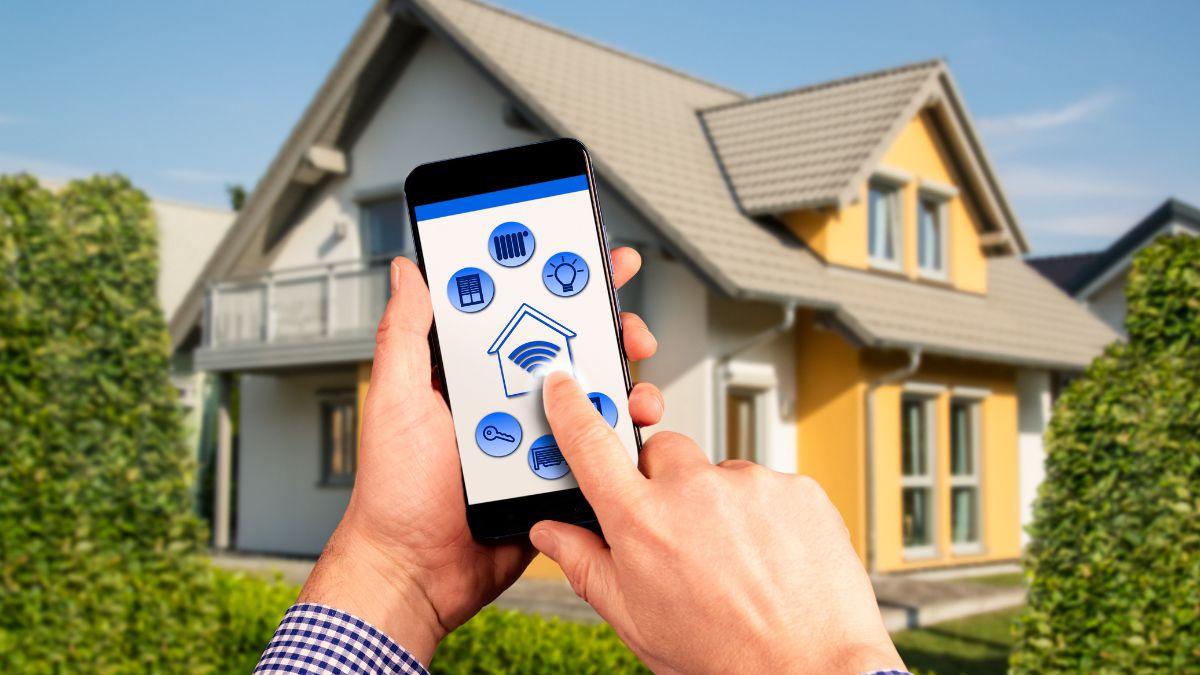 A person using a smartphone to control home automation settings, like security and lights, in front of a house.