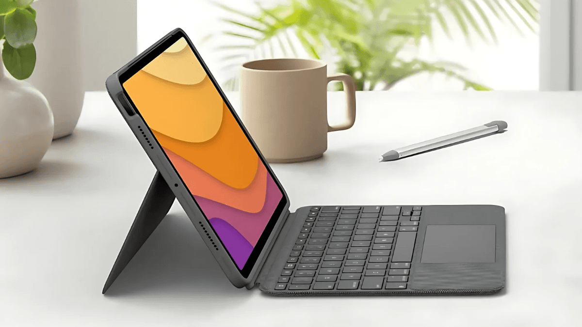 A tablet with a detachable keyboard and stylus on a minimalist desk, with a coffee mug and greenery in the background.