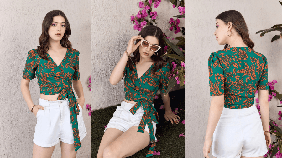 Woman wearing a green wrap top with an orange floral print, paired with high-waisted white shorts, posing in different angles against a floral background.