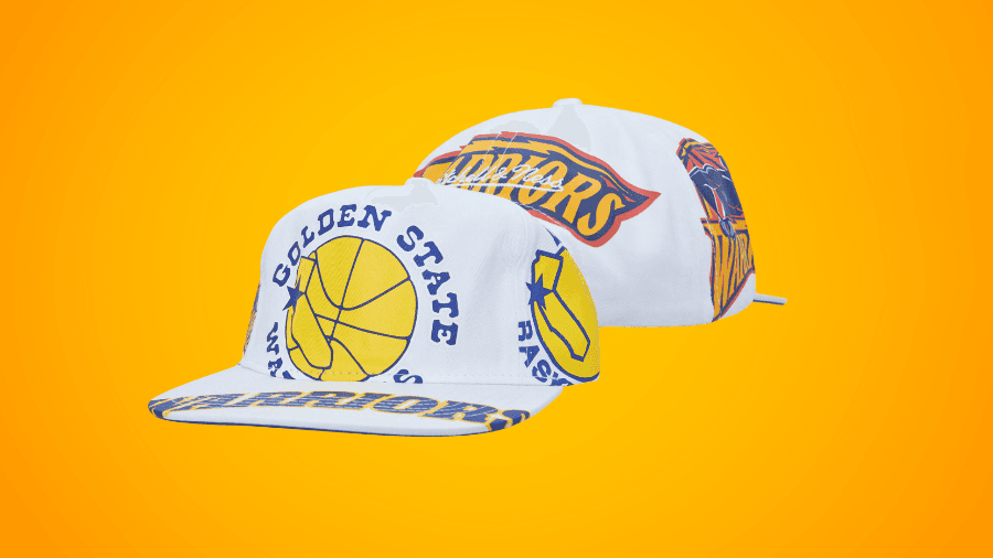 White Golden State Warriors snapback hats with bold yellow and blue graphics, including a basketball and team logos, displayed against an orange background.