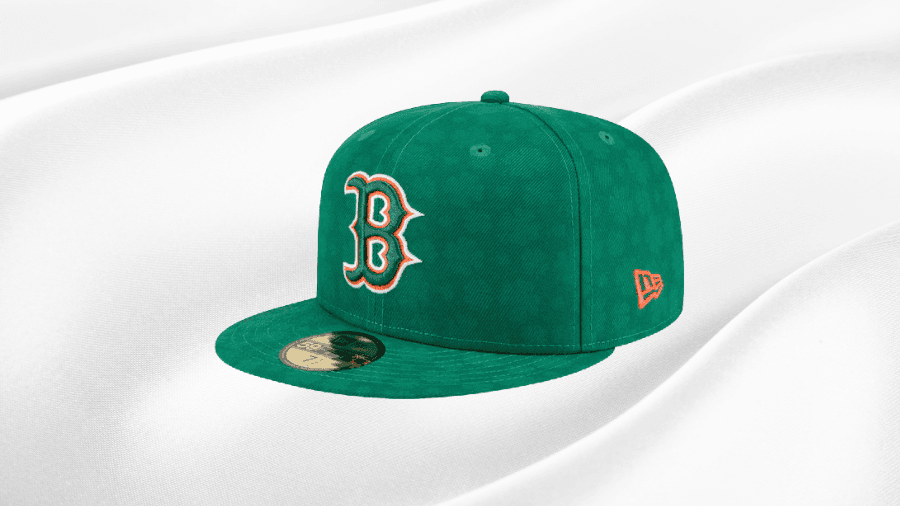 Green Boston Red Sox fitted cap featuring the iconic "B" logo with orange and white accents, set against a smooth white fabric backdrop.