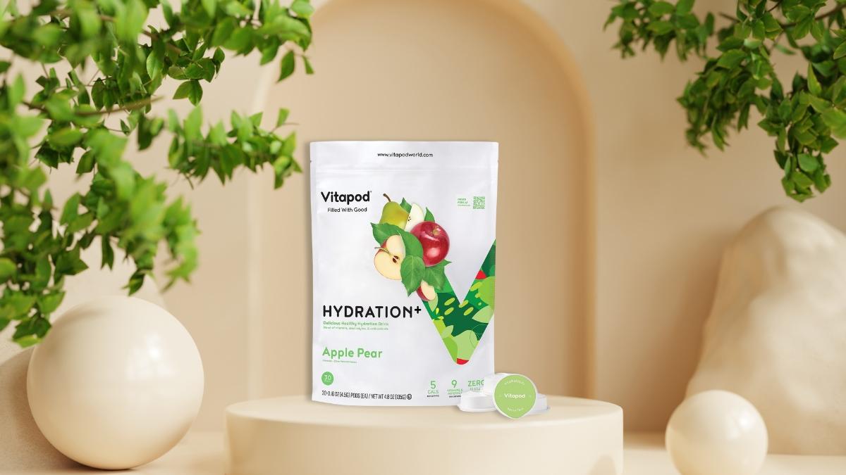 Vitapod Hydra+ Apple Pear hydration drink mix shown on a neutral background with fresh green leaves around it.