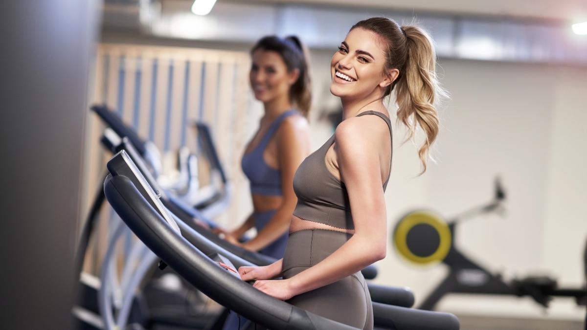 Women using JTX Fitness refurbished equipment treadmills in a modern home gym