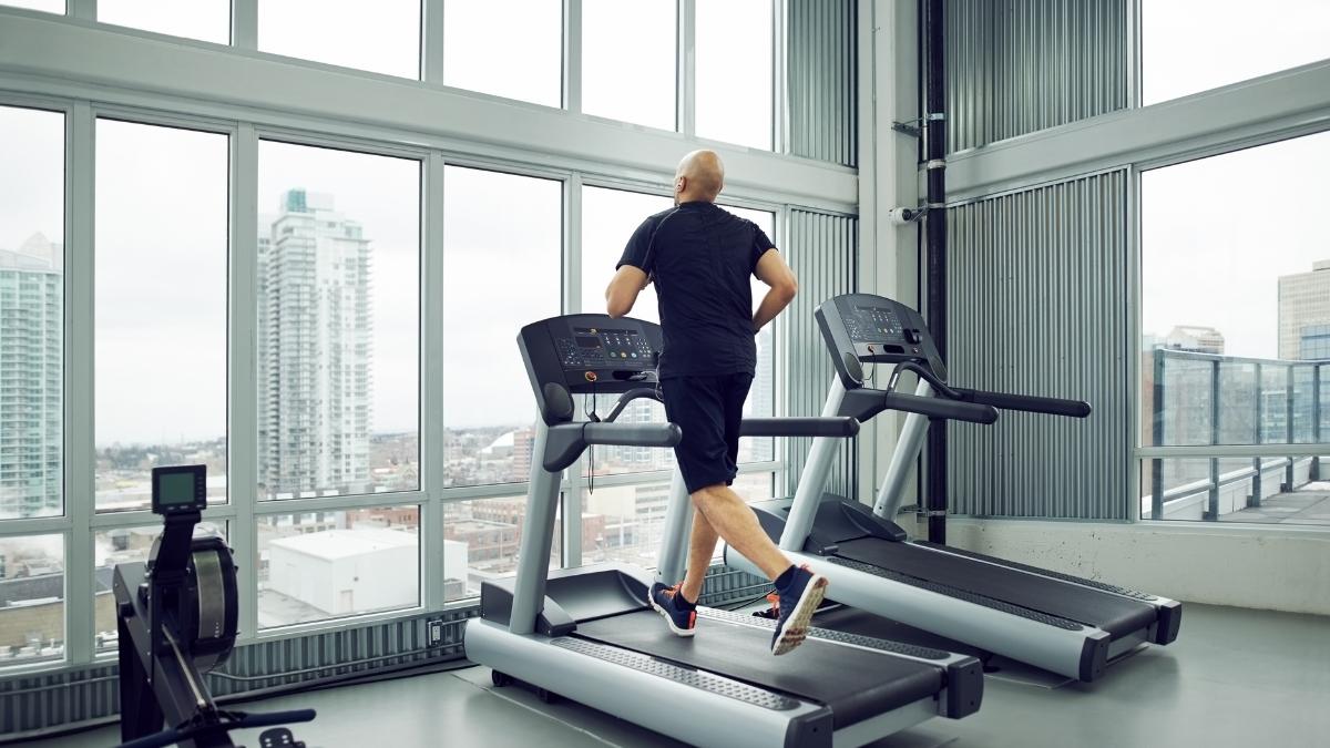 Person running on JTX Fitness treadmill during indoor cardio workout